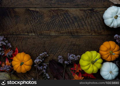 Table top view aerial image of decoration Happy Halloween or Thanksgiving day background concept.Flat lay accessory object to party the pumpkin & dry flower on brown wooden.Space for creative design.