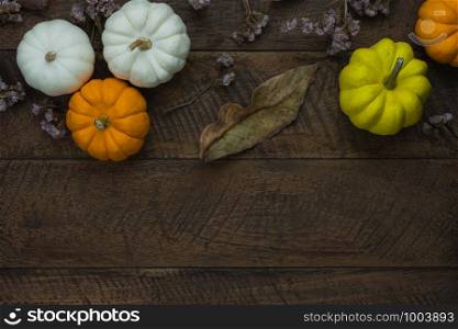 Table top view aerial image of decoration Happy Halloween or Thanksgiving day background concept.Flat lay accessory object to party the pumpkin & dry flower on brown wooden.Space for creative design.
