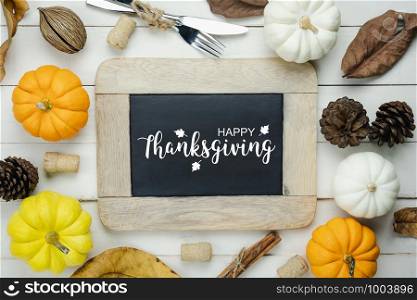 Table top view aerial image of decoration Happy Halloween or Thanksgiving day background concept.Flat lay accessory object to party the pumpkin & blackboard on white wooden.Text on season design.