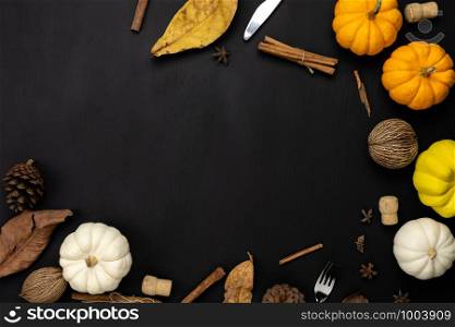 Table top view aerial image of decoration Happy Halloween or Thanksgiving day background concept.Flat lay accessory object to party the pumpkin & dry flower on black wooden.Space for creative design.