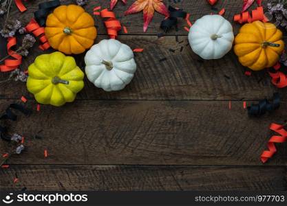 Table top view aerial image of decoration Happy Halloween or Thanksgiving day background concept.Flat lay accessory object to party the pumpkin & maple leaf on brown wooden.Space for creative design.