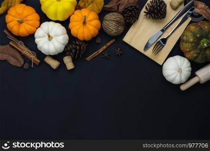 Table top view aerial image of decoration Happy Halloween or Thanksgiving day background concept.Flat lay accessory object to party the pumpkin & dinner set on black wooden.Space for creative design.