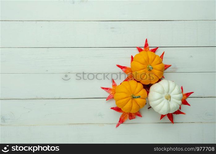 Table top view aerial image of decoration Happy Halloween or Thanksgiving day background concept.Flat lay accessories object to party the pumpkin & maple on white wooden.Space for creative design.