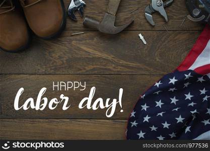 Table top view aerial image of decoration the sign of USA labor day on Sep 3,2018 background concept. Flat lay accessories US flag and essential tools worker on brown wooden with copy space and text.