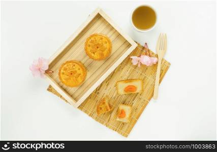 Table top view aerial image of decorations Chinese Moon Festival or lunar new year background concept.Flat lay essential meal set for coffee break of sweet cake & tea with blossom on white wooden.