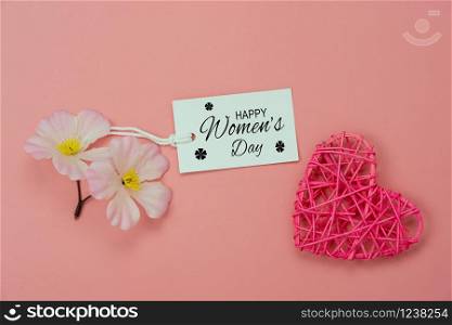 Table top view aerial image of decorations for international women&rsquo;s day holiday concept background.Flat lay sign of season the word 8 march happy woman&rsquo;s day with flower and card on pink paper.