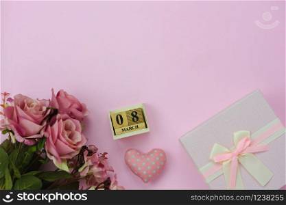 Table top view aerial image of decorations for international women&rsquo;s day holiday concept background.Flat lay sign of season the word 8 march happy woman&rsquo;s day with flower and gift box on pink paper.