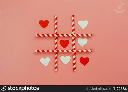 Table top view aerial image of decorations valentine&rsquo;s day holiday background concept.Flat lay essential items red heart shape with straw idea game of love on modern pink paper.