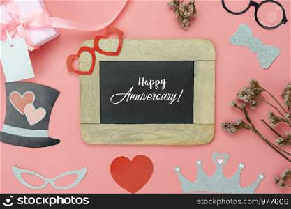 Table top view aerial image of sign anniversary day background concept.Photo booth props on modern grunge pink wallpaper at home office desk studio.Space for creative design mock up & templates.