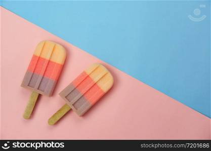Table top view aerial image of sign or food of summer season holiday background concept.Flat lay of pastel ice cream on modern rustic pink & blue paper backdrop.Minimalism creative design. copy space