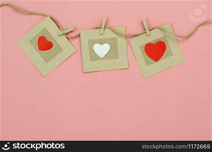 Table top view aerial image of valentine &rsquo;s day background concept.Love text hang on rope clotheslines.Flat lay on modern rustic pink paper.pastel tone.Items create by handmade sign for the season.