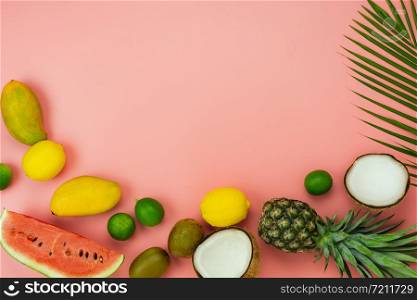 Table top view fruit tropical with spring summer holiday & vacation background concept.Arrangement sliced various pineapple mango lemon and lime on palm green leaves.Items on pink paper.pastel.