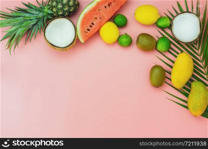 Table top view fruit tropical with spring summer holiday & vacation background concept.flat lay arrangement sliced various watermelon pineapple kiwi mango lemon and lime coconut on pink paper.