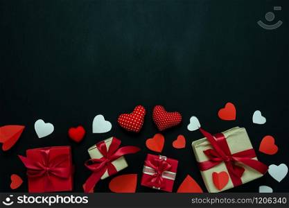 Table top view image of decoration valentine&rsquo;s day background concept.Flat lay arrangement of red shape & gift box with essential items on modern rustic black wood with middle space for mock up design