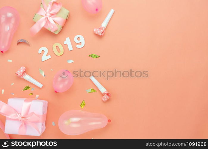 Table top view of Merry Christmas decorations & Happy new year 2019 ornaments concept.Flat lay essential difference objects gift box & balloon with golden confetti on modern pink paper background.