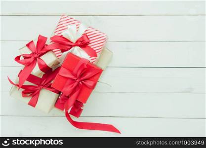 Table top view of Merry Christmas decorations & Happy new year ornaments concept.Flat lay essential difference objects many gift box on wood white background at home studio office desk.Space for text.
