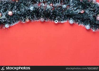 Table top view of Merry Christmas decorations & Happy new year ornaments concept.Flat lay essential difference objects baubles & fir tree on modern red paper background at home studio office desk.