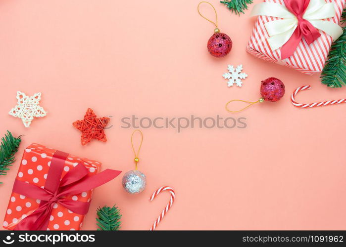 Table top view of Merry Christmas decorations & Happy new year ornaments concept.Flat lay essential difference objects gift box & fir tree on modern pink paper background at home studio office desk.