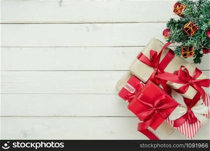 Table top view of Merry Christmas decorations & Happy new year ornaments concept.Flat lay essential difference objects decor fir tree & gift box on modern white wooden background.Copy space for design