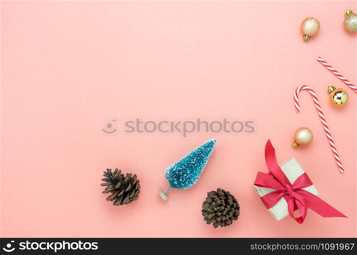 Table top view of Merry Christmas decorations & Happy new year ornaments concept.Flat lay essential difference objects gift box & fir tree with pine cones and decor on modern pink paper background.