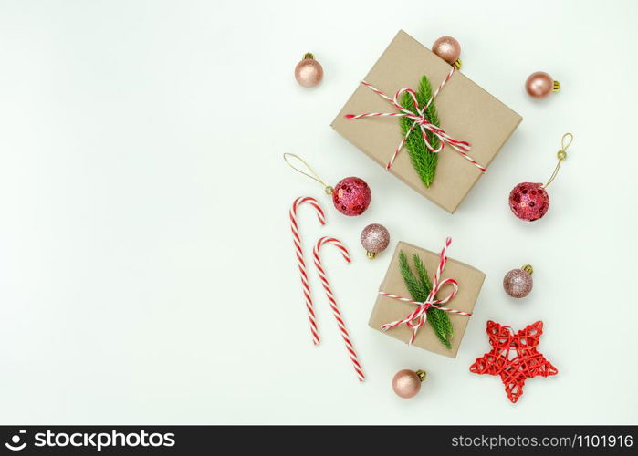 Table top view of Merry Christmas decorations & Happy new year ornaments concept.Flat lay essential difference objects gift box & fir tree on modern white paper background at home studio office desk.