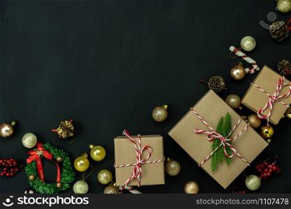 Table top view of Merry Christmas decorations & Happy new year ornaments concept.Flat lay essential difference objects gift box & fir tree on modern black paper background at home studio office desk.