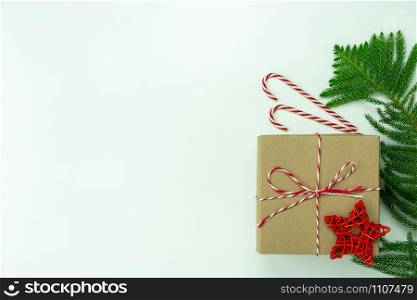 Table top view of Merry Christmas decorations & Happy new year ornaments concept.Flat lay essential difference objects gift box & fir tree on modern white paper background at home studio office desk.