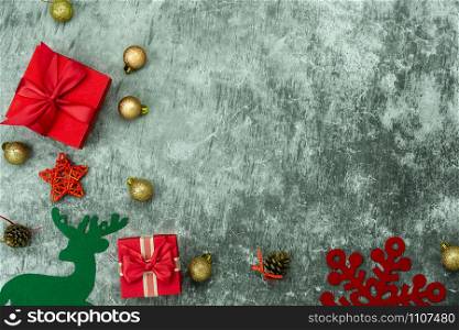 Table top view of Merry Christmas decorations & Happy new year ornaments concept.Flat lay essential difference objects gift box & baubles on modern red paper background at home studio office desk.
