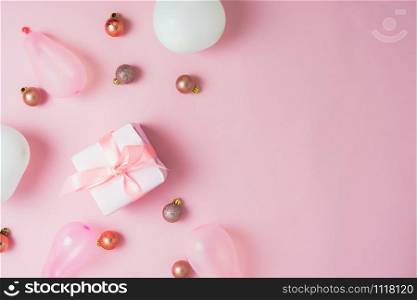 Table top view of Merry Christmas decorations & Happy new year ornaments concept.Flat lay essential objects the baubles & gift box on modern rustic pink paper background at home studio office desk.