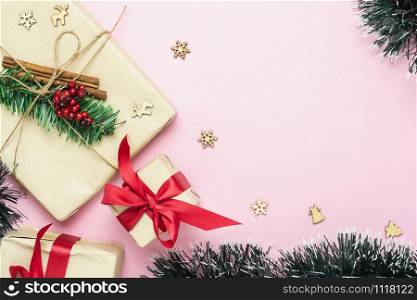 Table top view of Merry Christmas decorations & Happy new year ornaments concept.Flat lay essential objects the pine tree & gift box on modern rustic pink paper background at home studio office desk.