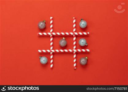 Table top view of Merry Christmas decorations & Happy new year ornaments concept.Flat lay essential object the game bauble or crystal ball & straw on red paper background at home studio office desk.