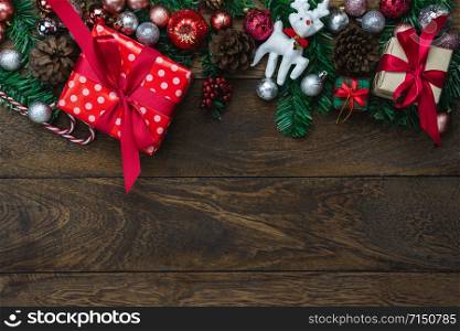 Table top view of Merry Christmas decorations & Happy new year ornaments concept.Flat lay essential objects the fir tree & gift box on modern rustic wood brown background at home studio office desk.