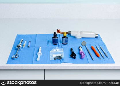 Table with a blue sterile tablecloth with dentist&rsquo;s tools in a clinic. Table with a sterile tablecloth with tools for a dentist