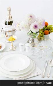 table with dishes and flowers on a white background