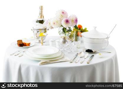 table with dishes and flowers on a white background