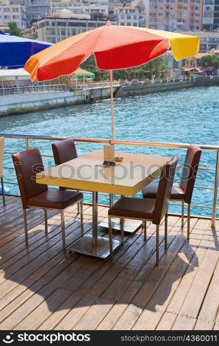 Table with four chairs under a patio umbrella in a restaurant, Ephesus, Turkey