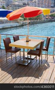 Table with four chairs under a patio umbrella in a restaurant, Ephesus, Turkey
