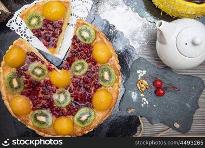 Table with fruit cakes. Table with fruit cakes and teapot