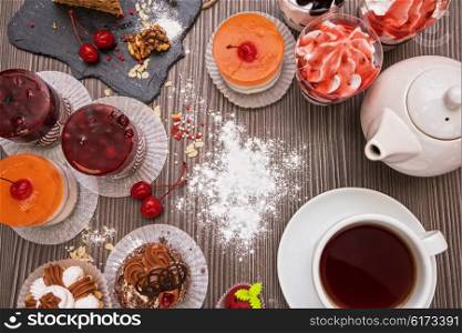 Table with fruit cakes . Table with fruit cakes and teapot
