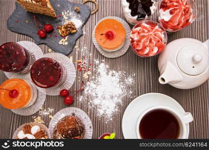 Table with fruit cakes. Table with fruit cakes and teapot