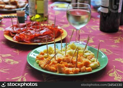 table with glass of white wine and food for appetizer