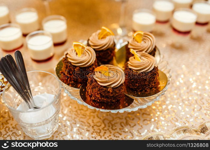 Table with sweets and goodies for the wedding party reception, decorated dessert table. Delicious sweets on candy buffet. Dessert table for a party. cakes, cupcakes. Table with sweets and goodies for the wedding party reception, decorated dessert table. Delicious sweets on candy buffet. Dessert table for a party. cakes, cupcakes.