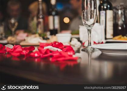 Table with wine and petals of roses.. Petals of roses on a table 2100.