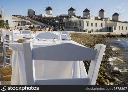 Tables and chairs in a restaurant at the coast, Mykonos, Cyclades Islands, Greece