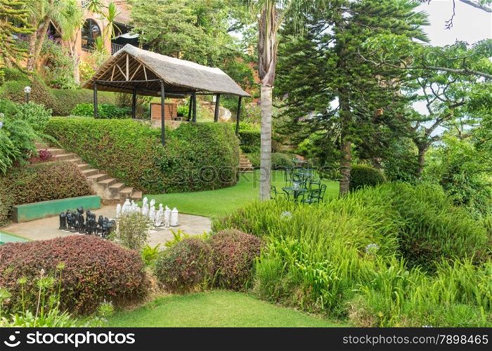 Tables set in a beautiful garden with gigantic trees in the the Mountains