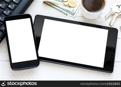 Tablet and smartphone with white blank screen on wooden table