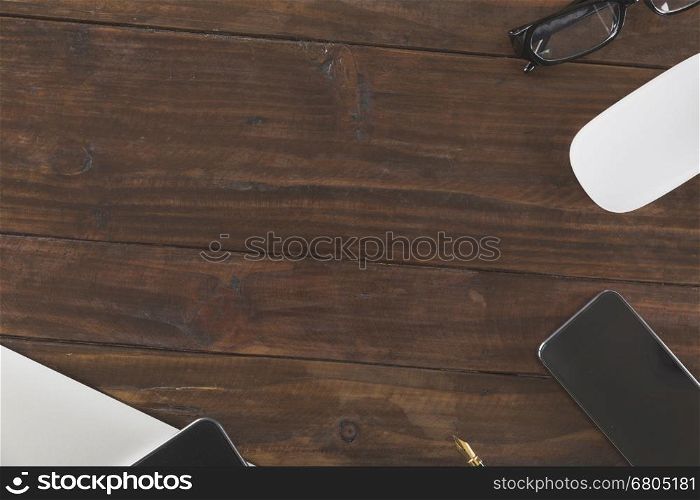 tablet, computer notebook and mobile phone on wooden office desk - top view