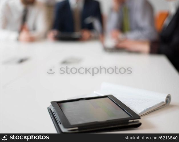 tablet computer with group of people on meeting in background