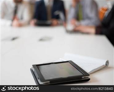 tablet computer with group of people on meeting in background