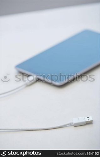 Tablet computer with USB cable laying on a table